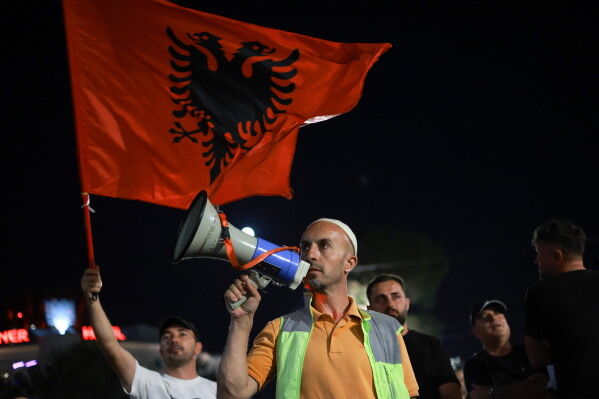Arben Kola, a tour guide and one of the protesters against a coastal development project in western Albania linked to Donald Trump's son-in-law Jared Kushner, is photographed during a rally in Tirana, Albania, Saturday, June 27, 2026. (AP Photo/Hameraldi Agolli)