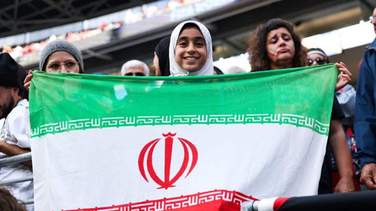 An Iran fan proudly waves their flag during the Egypt vs Iran