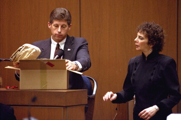 Los Angeles Police Detective Mark Fuhrman shows the jury in the O.J. Simpson double murder trial evidence during testimony Friday, March 10, 1995, in Los Angeles. (AP Photo/Nick Ut, Pool, File)