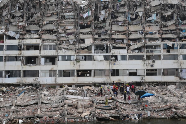 Rescue workers search through the rubble of a building that collapsed when earthquakes struck La Guaira, Venezuela, Sunday, June 28, 2026. (AP Photo/Matias Delacroix)