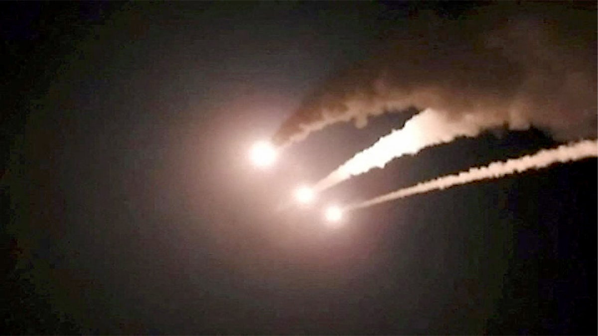 Iranian missiles are seen in dark sky.