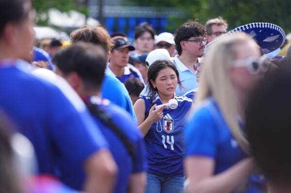 Japan soccer fans gather in the heat in downtown Dallas, Wednesday, June 24, 2026. (AP Photo/LM Otero)