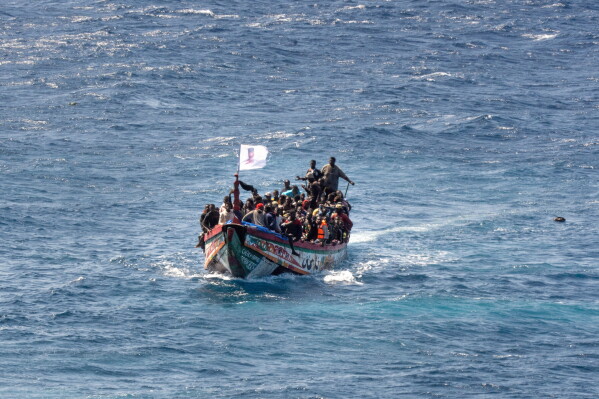 Migrants crowd a wooden boat as they sail to the port in La Restinga on the Canary island of El Hierro, Spain, Sunday, Aug. 18, 2024. (AP Photo/Maria Ximena, File)