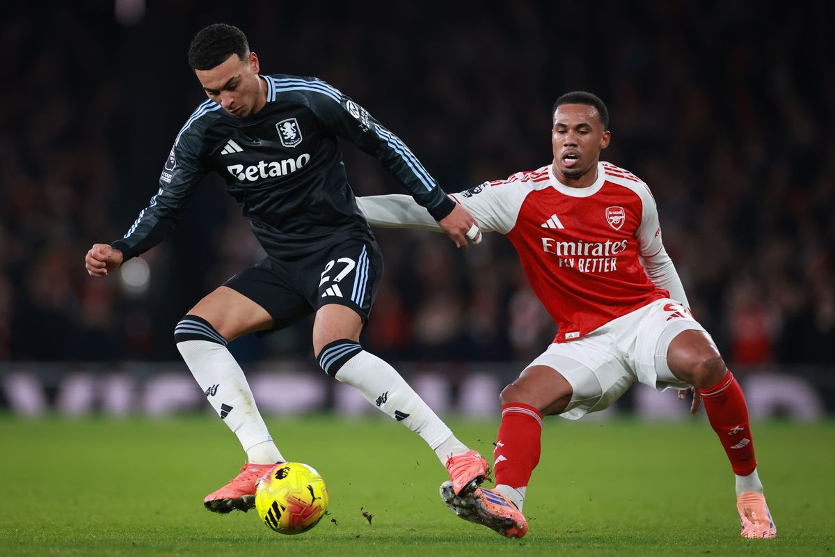 Morgan Rogers of Aston Villa under pressure from Gabriel Magalhaes of Arsenal during the Premier League match between Arsenal and Aston Villa at Emirates Stadium on December 30, 2025 in London, England.