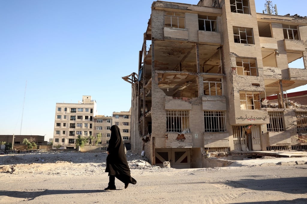 An Iranian woman walks past a residential building destroyed by previous US-Israeli strikes, in Tehran on Tuesday. Photo: EPA