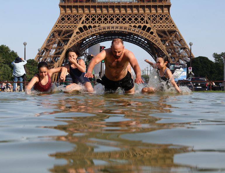 People cool off in the Trocadero Fountain next to the Eiffel Tower as temperatures rise during a heatwave affecting a large part of the country, in Paris, June 22, 2026 [Abdul Saboor/Reuters]