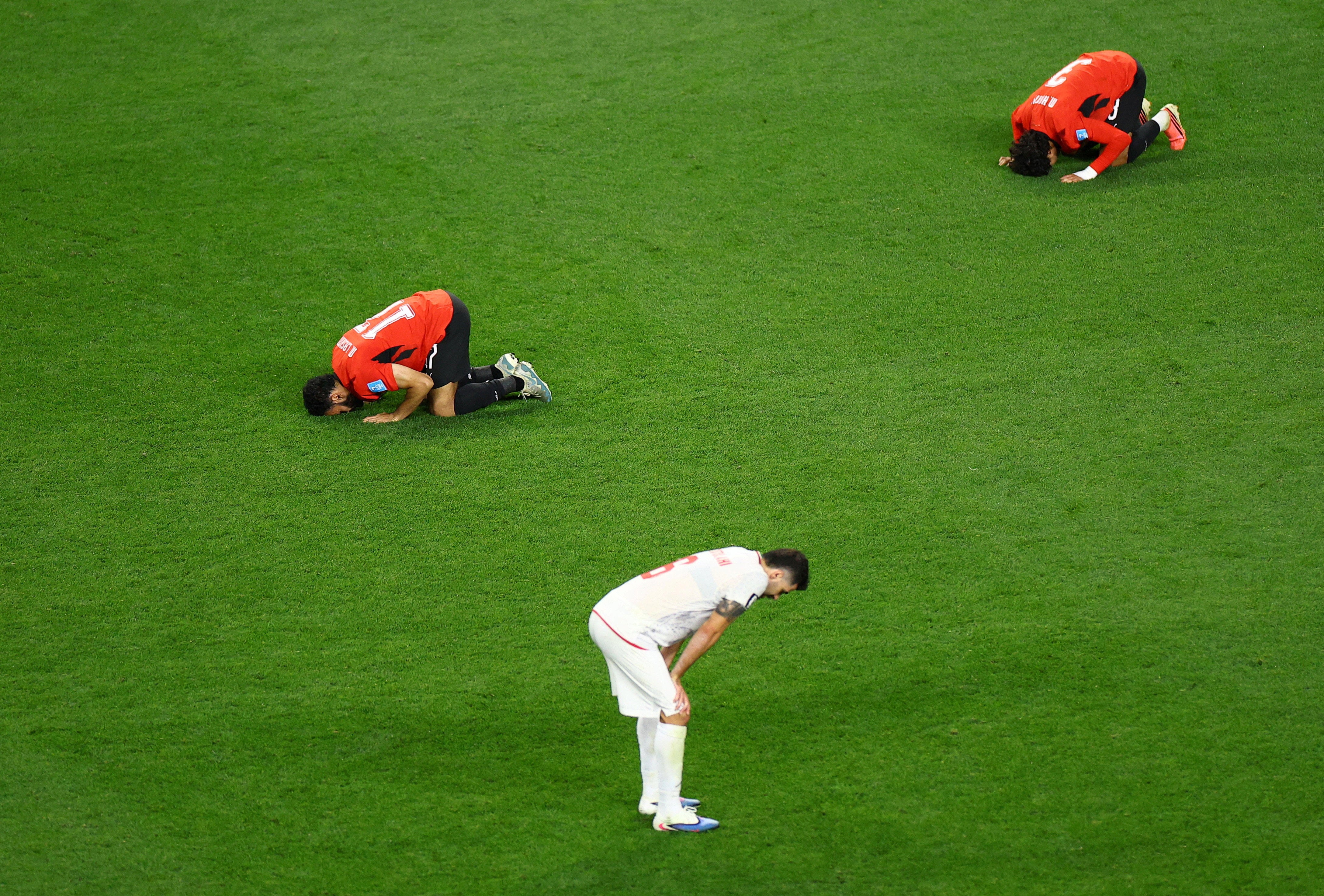 Egypt's Mohanad Lashin and Egypt's Mohamed Hany celebrate as Iran's Saeid Ezatolahi looks dejected after the match