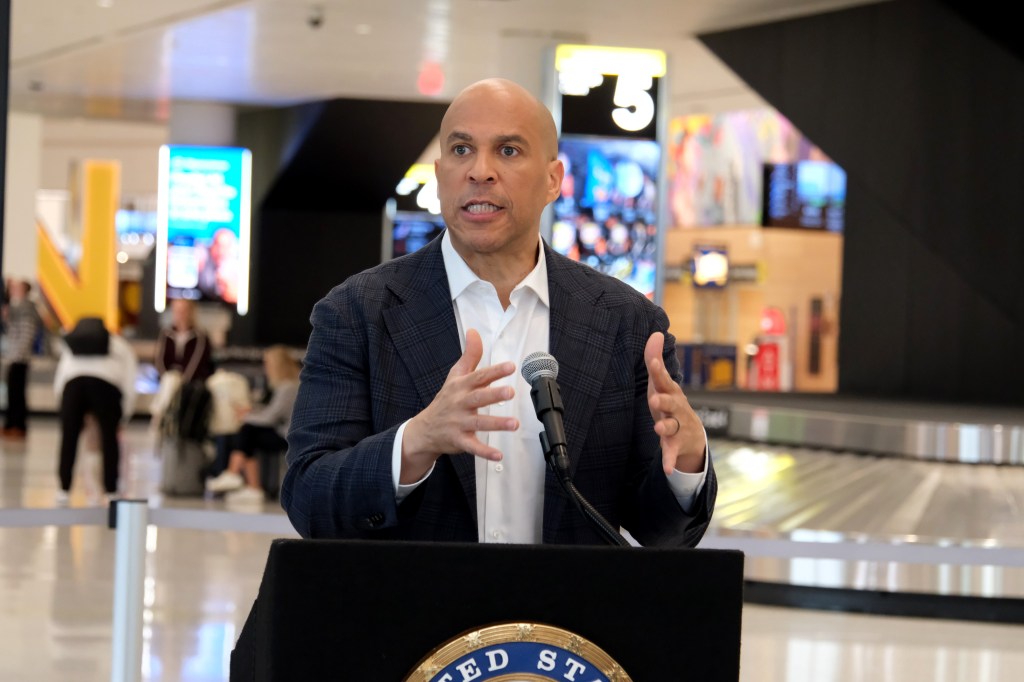 Sen. Cory Booker speaking during a press conference at Newark Liberty International Airport, criticizing the deployment of ICE agents and the ongoing government shutdown.