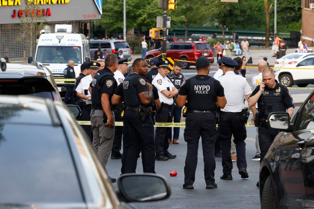 NYPD officers investigate the scene after an officer was struck by a suspected stolen vehicle.
