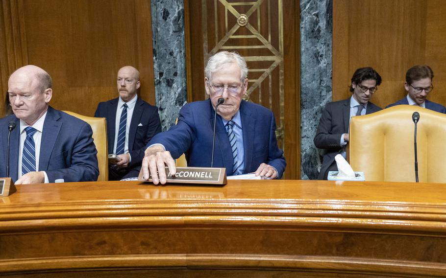 McConnell reaches out to put the nameplate in place.