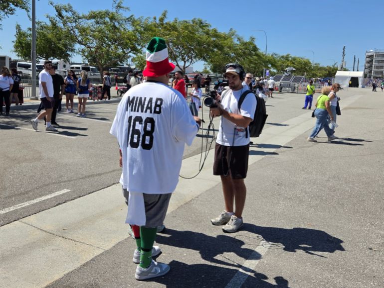 Man with white shirt that says minab 168