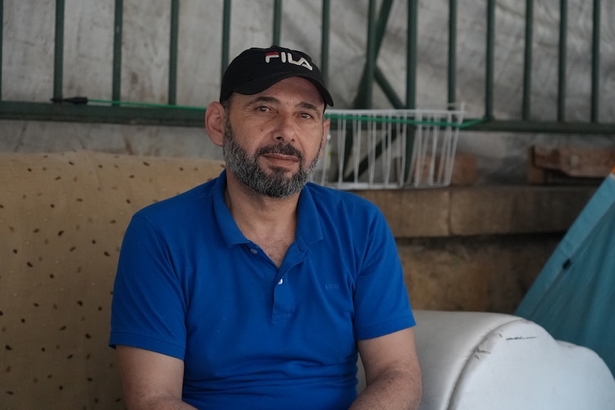 A close up of a man wearing a blue shirt.