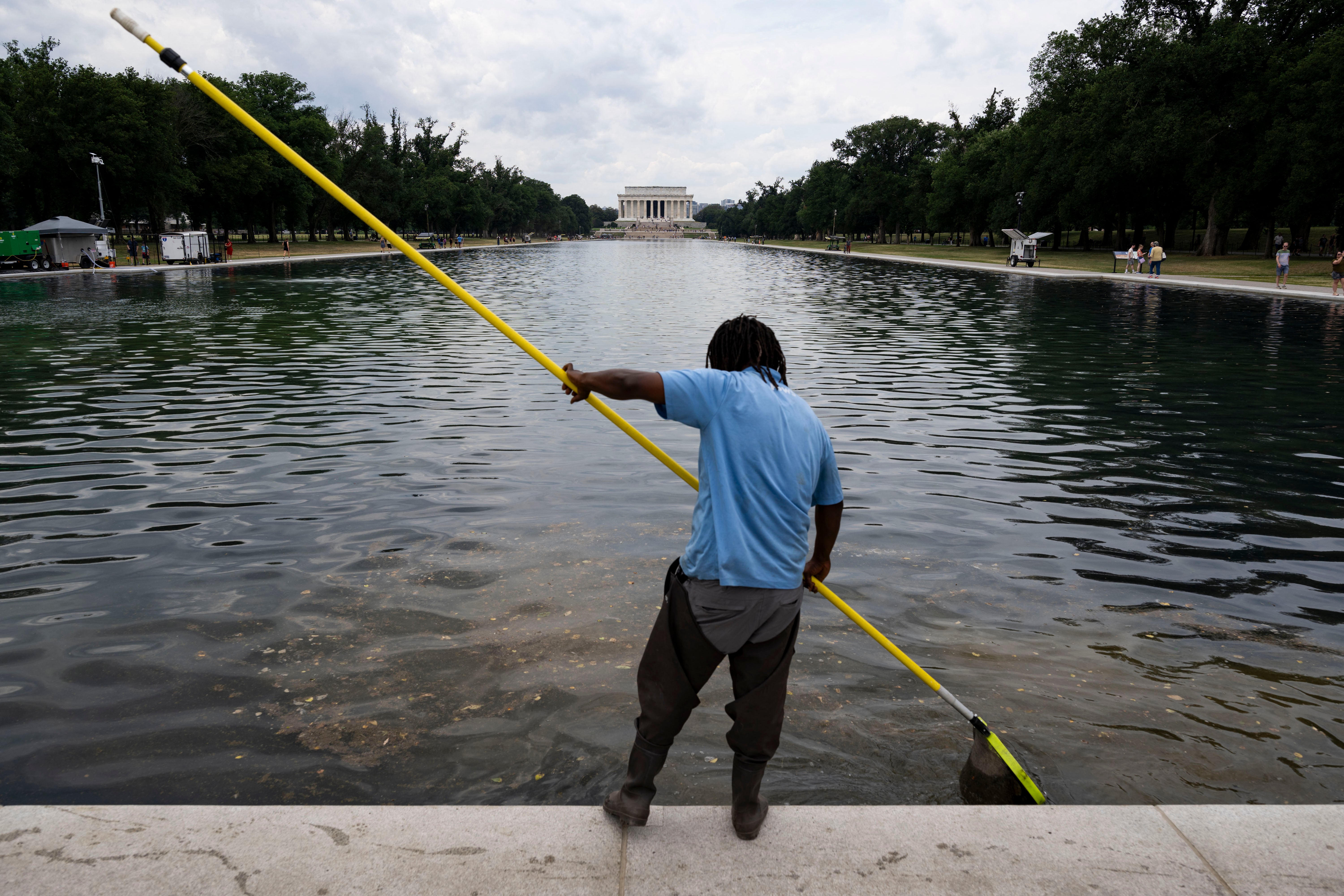 A worker cleans algae and chunks of paint from the Lincoln Memorial Reflecting Pool on Monday