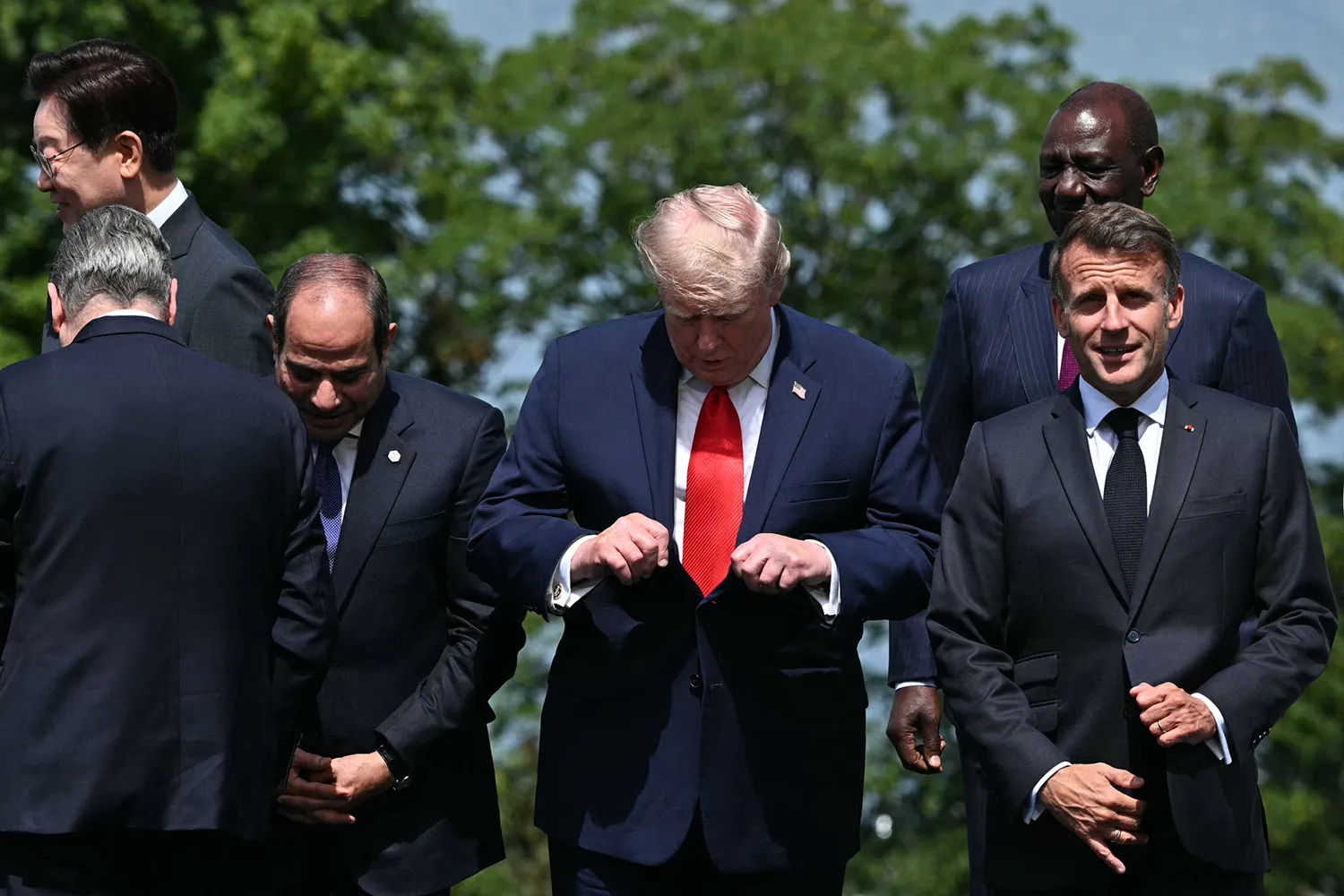 Trump adjusts his suit during the G-7 summit in Évian.