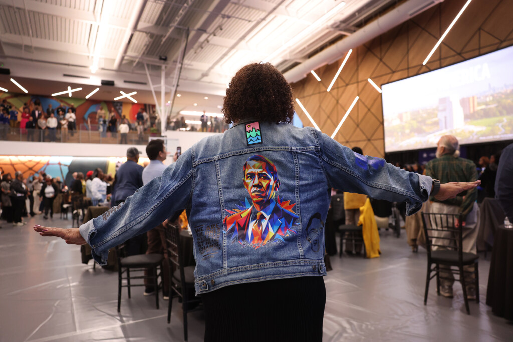 A woman wears a jean jacket adorned with an image...