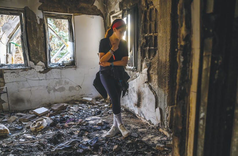 VOLUNTEER from London visits a home gutted by fire in Be’eri.