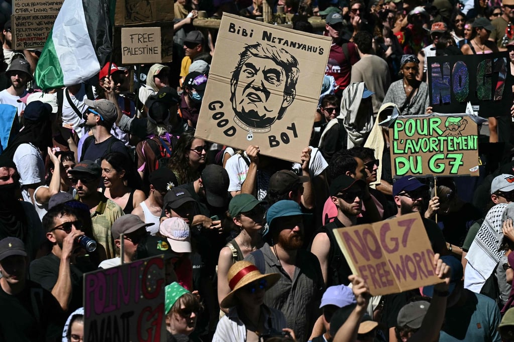 Demonstrators with placards, including one (centre) depicting US President Donald Trump and reading ‘Bibi Netanyahu’s good boy’ during an anti-G& rally ahead of the group’s summit in Geneva, on Sunday. Photo: AFP