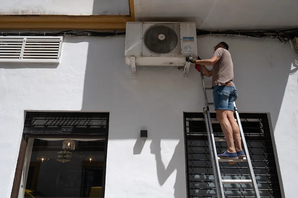 a man repairs and air con unit
