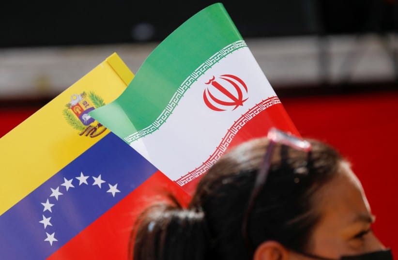 A Venezuelan government supporter holds the flags of Iran and Venezuela while participating in a march in support of Iran, amid the ongoing conflict between Israel and Iran, in Caracas, Venezuela, June 19, 2025.
