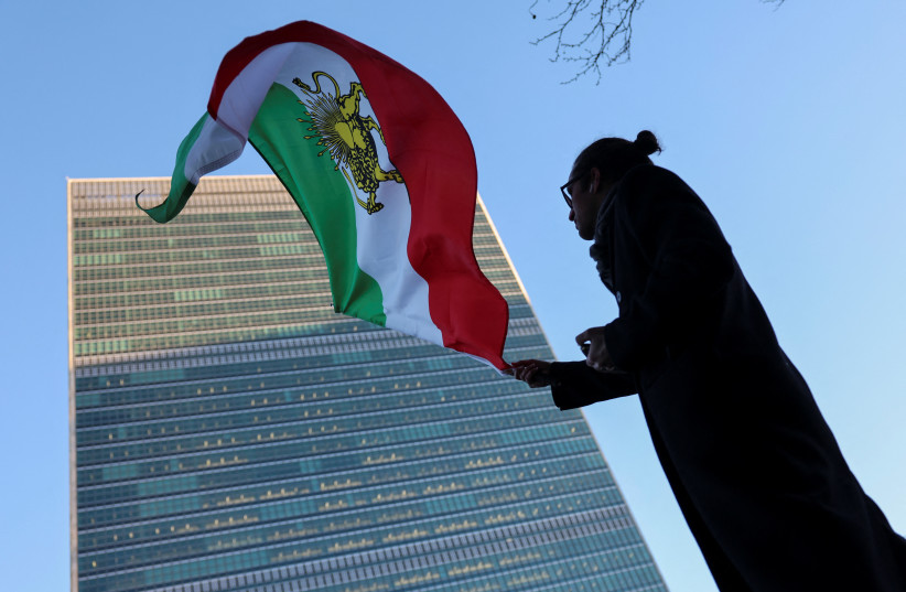A protester waves the pre-Islamic Revolution Iranian flag outside UN headquarters during a United Nations Security Council meeting on Iran in New York on January 15, 2026.