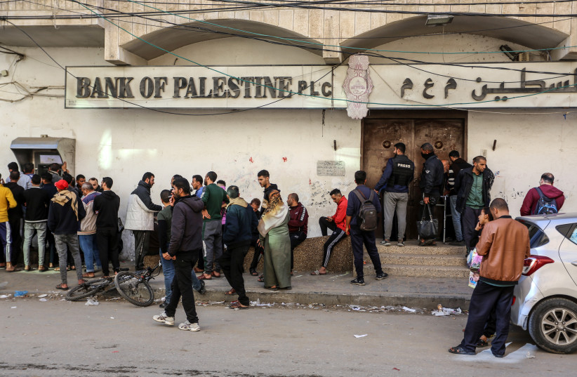 Employees of the Palestinian Authority line up at the ATM outside the Bank of Palestine in Rafah, in the southern Gaza Strip, on December 8, 2023