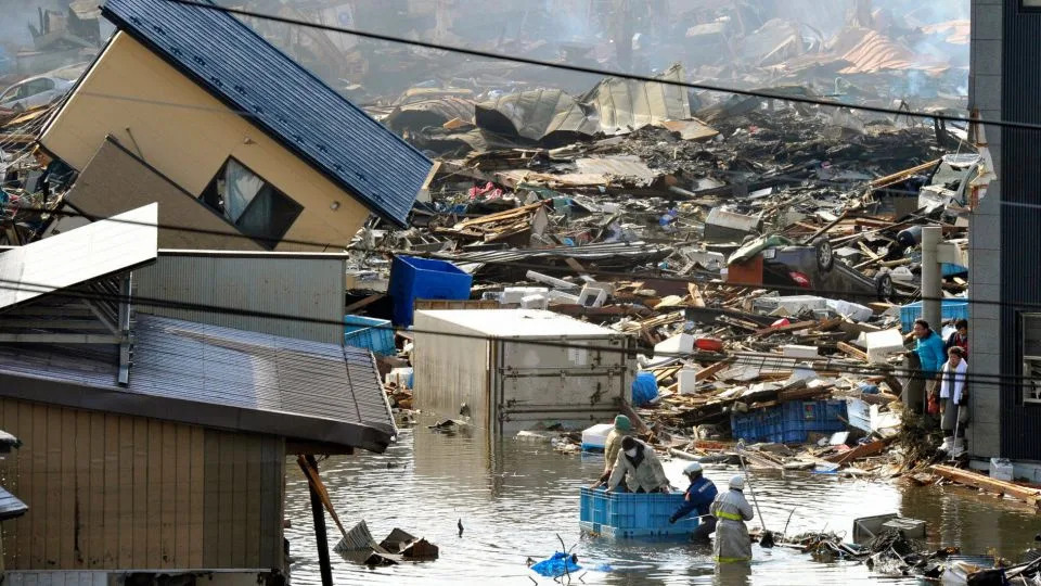 People in a floating container are rescued from a building following the earthquake and tsunami in Miyagi Prefecture, northeastern Japan. - Kyodo/Reuters