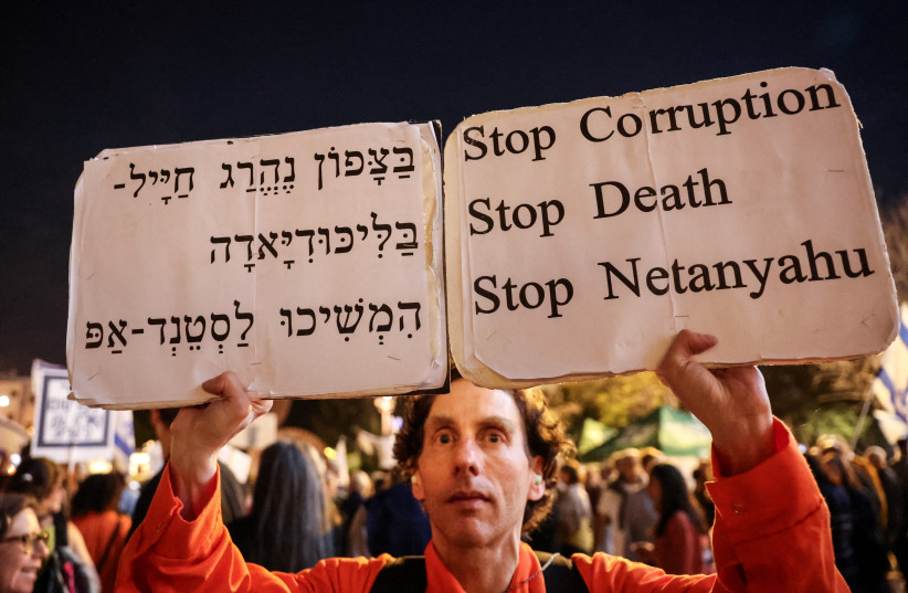 An Israeli left-wing activist holds up placards during a protest in Habima Square against the ongoing war with Iran and against the Israeli government, in Tel Aviv on May 2, 2026.