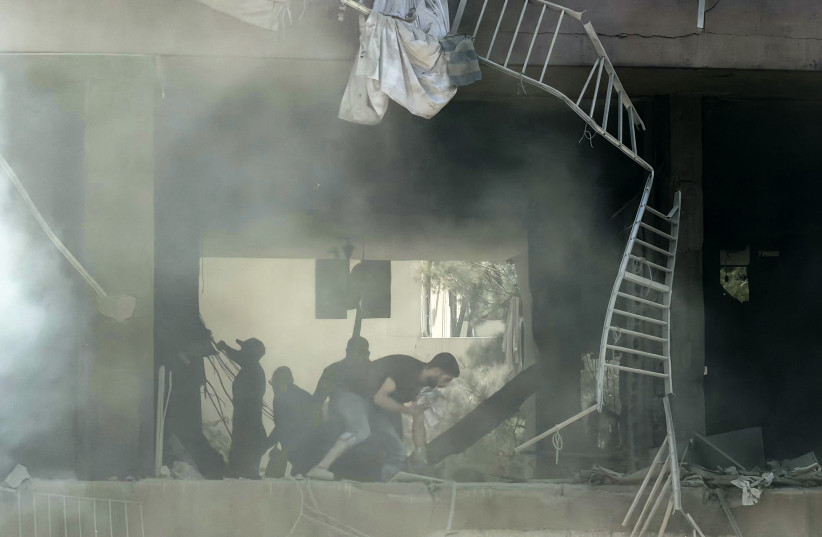 People look for survivors at the site of an Israeli airstrike that targeted a building in Beirut's southern suburbs on June 14, 2026.