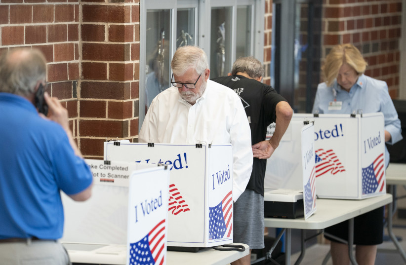 People fill out ballots as a poll worker makes a phone call on Election Day for the midterm primary on June 9, 2026 at Dreher High School in Columbia, South Carolina.