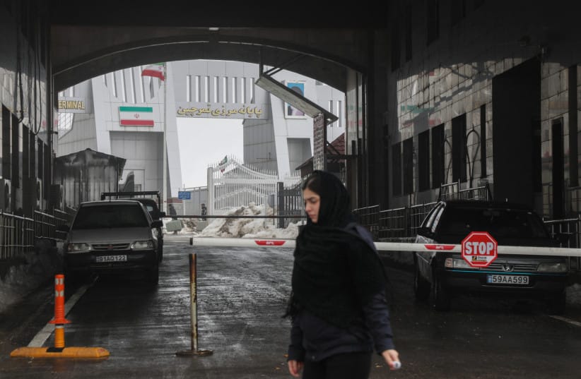 n Iraqi Kurdish border employee walks outside at the Haji Omran border crossing with Iran (Iranian flag in the background), in Iraq's autonomous northern Kurdish region, on February 1, 2026.