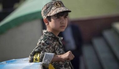 A child dressed in a military-style uniform attends a public gathering in Iran.