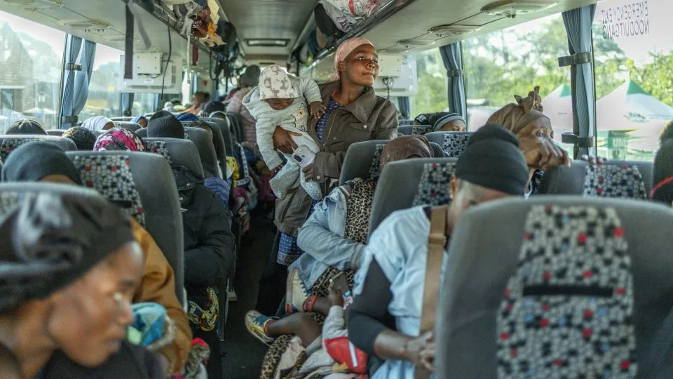 Displaced women and children from Malawi board the first bus to leave at an abandoned municipality building in Pietermaritzburg on June 23, after fleeing their homes amid fears of xenophobic attacks and threats against illegal migrants. - Rajesh Jantilal/AFP/Getty Images