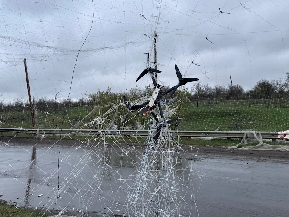 Remains of a drone hang on anti-drone net on Kostiantynivka-Kramatorsk road i n April 2026 in Donetsk