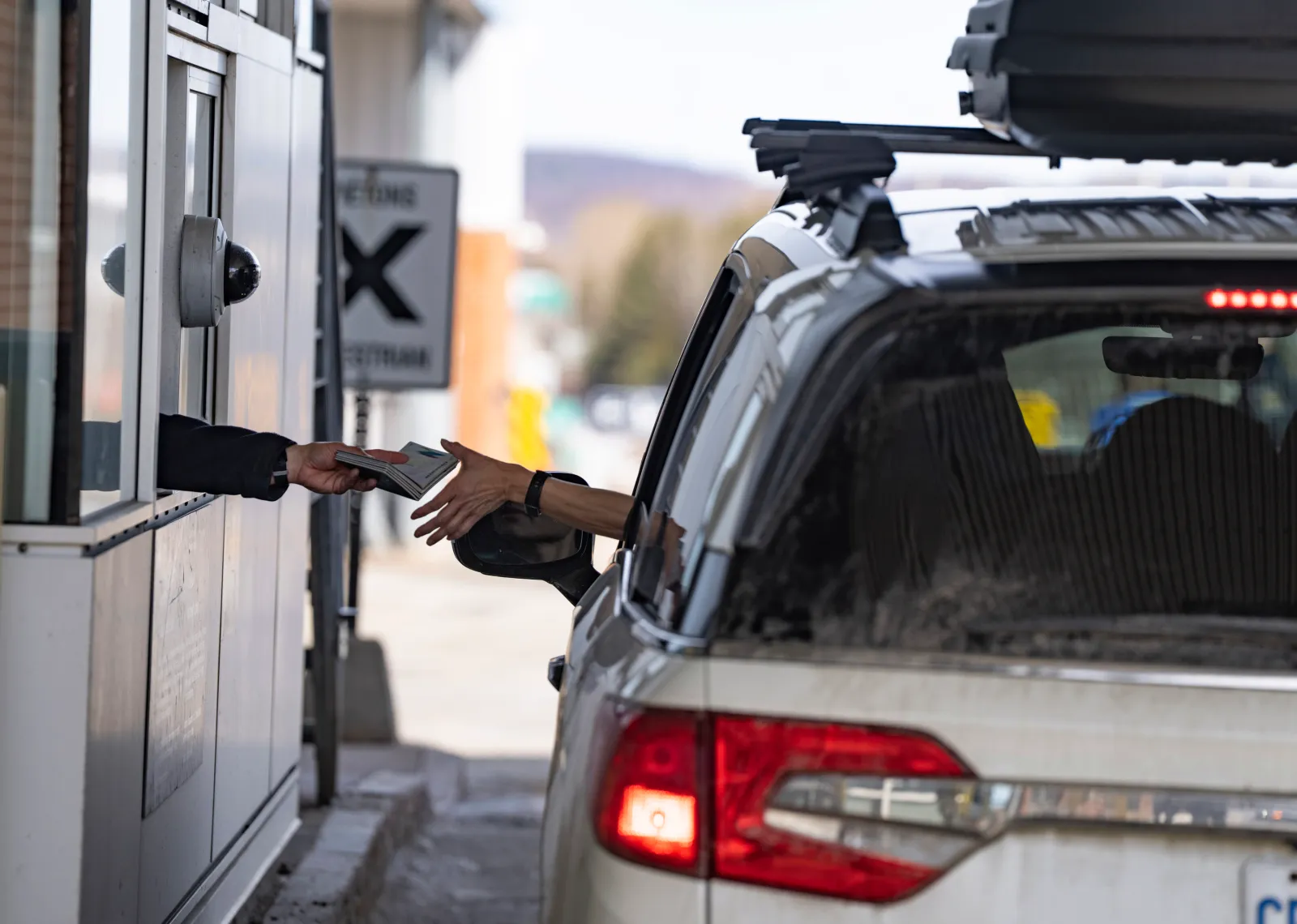A Canada Border Services officer is handed passports from a visitor entering Canada from Vermont, U.S., at the Highway 55 Port of Entry in Stanstead, Quebec, on March 13, 2025.