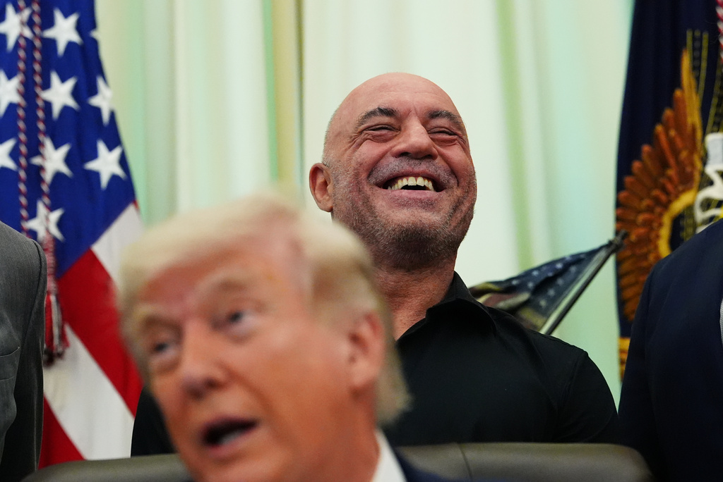 Joe Rogan laughs as President Donald Trump speaks in the Oval Office of the White House, Saturday, April 18, 2026, in Washington.