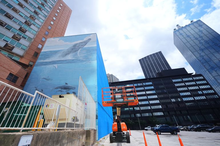 A section of a mural, known as the "Whaling Wall 82," created by artist Wyland, is visible as part of it on the right side of the building was painted over, Monday, May 18, 2026, in Dallas. (AP Photo/Julio Cortez)