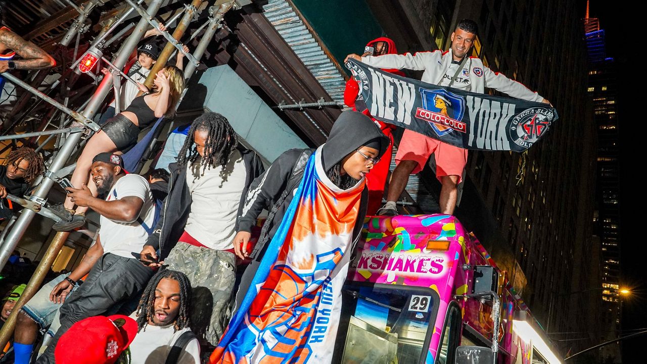 New York Knicks fans celebrate on the street outside of a watch party in Bryant Park for Game 3 of the NBA Finals basketball series between the Knicks and the San Antonio Spurs, Monday, June 8, 2026. (AP Photo/Ryan Murphy)