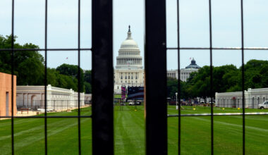 The Capitol is seen through a construction zone security fence as workers continue to build event space for the America 250 celebrations on the National Mall in Washington, Tuesday, June 9, 2026.