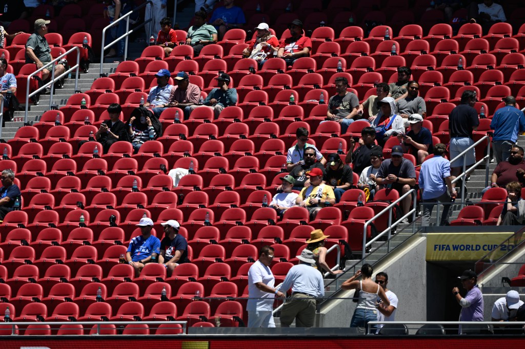 Soccer fans sitting in red stadium seats at the Switzerland vs. Qatar World Cup.