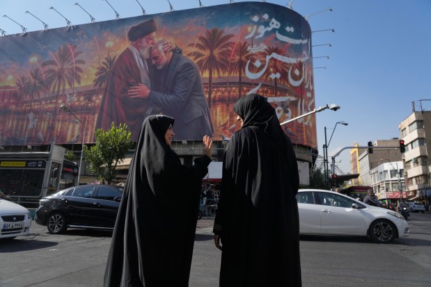 A banner depicts Iranian Supreme Leader Ayatollah Ali Khamenei and Gen. Qassem Soleimani.