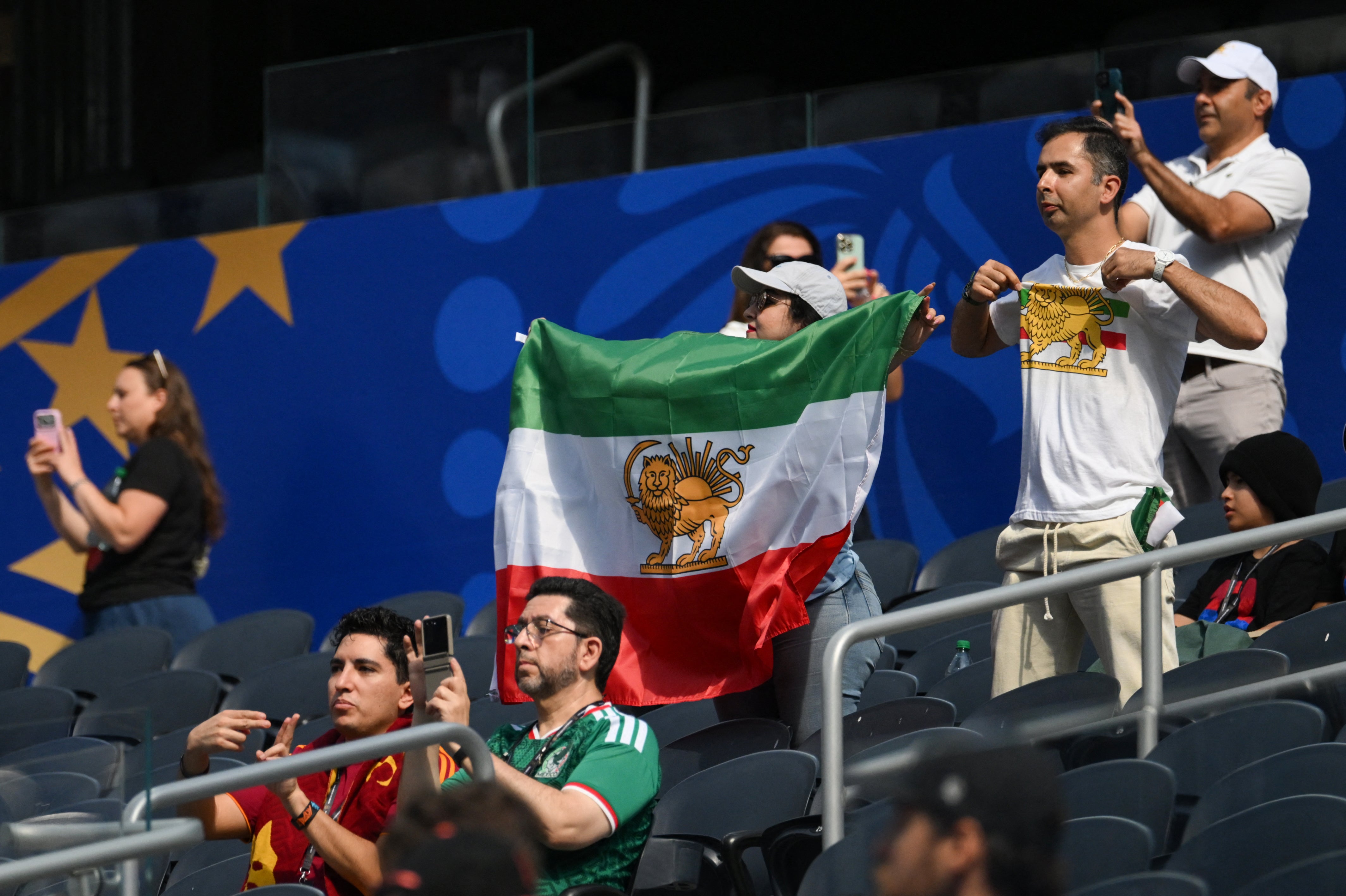 An Iranian fan shows a pre-revolutionary Iranian flag ahead of the 2026 World Cup Group G football match between Iran and New Zealand at Los Angeles Stadium
