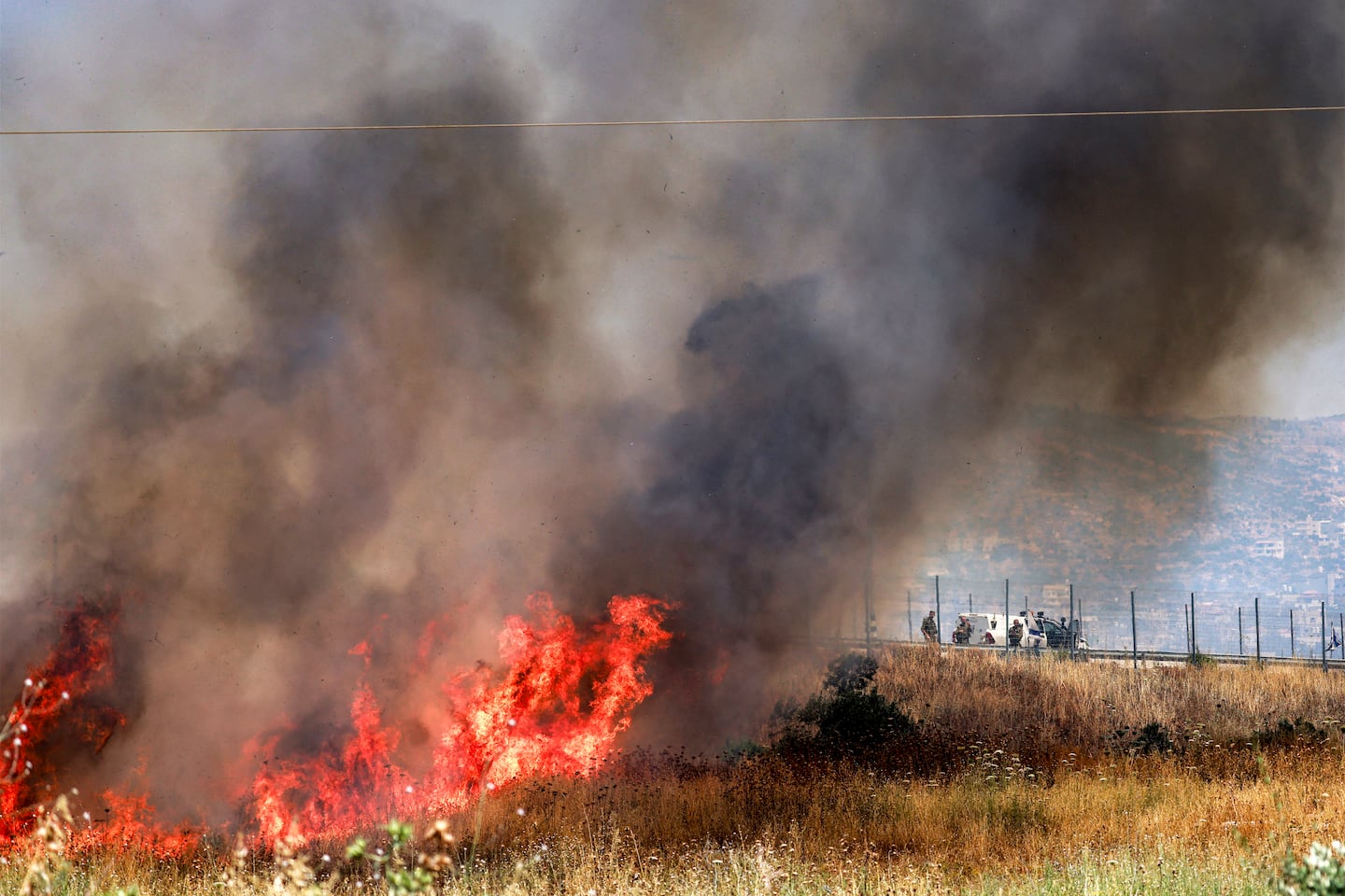 Israeli forces look on as a fire blazes in a field in the Palestinian town of Huwara in the occupied West Bank on June 6, 2026, after a reported arson attack by Israeli settlers according to local officials. Shielded by what Palestinians and rights group describe as complete impunity from the law, some Israeli settlers have harassed rural Palestinian communities, vandalising property, committing arson, sometimes killing. Excluding east Jerusalem, more than 500,000 Israelis live in the occupied West Bank in settlements that are illegal under international law, among some three million Palestinians. Israel has occupied the West Bank since 1967.