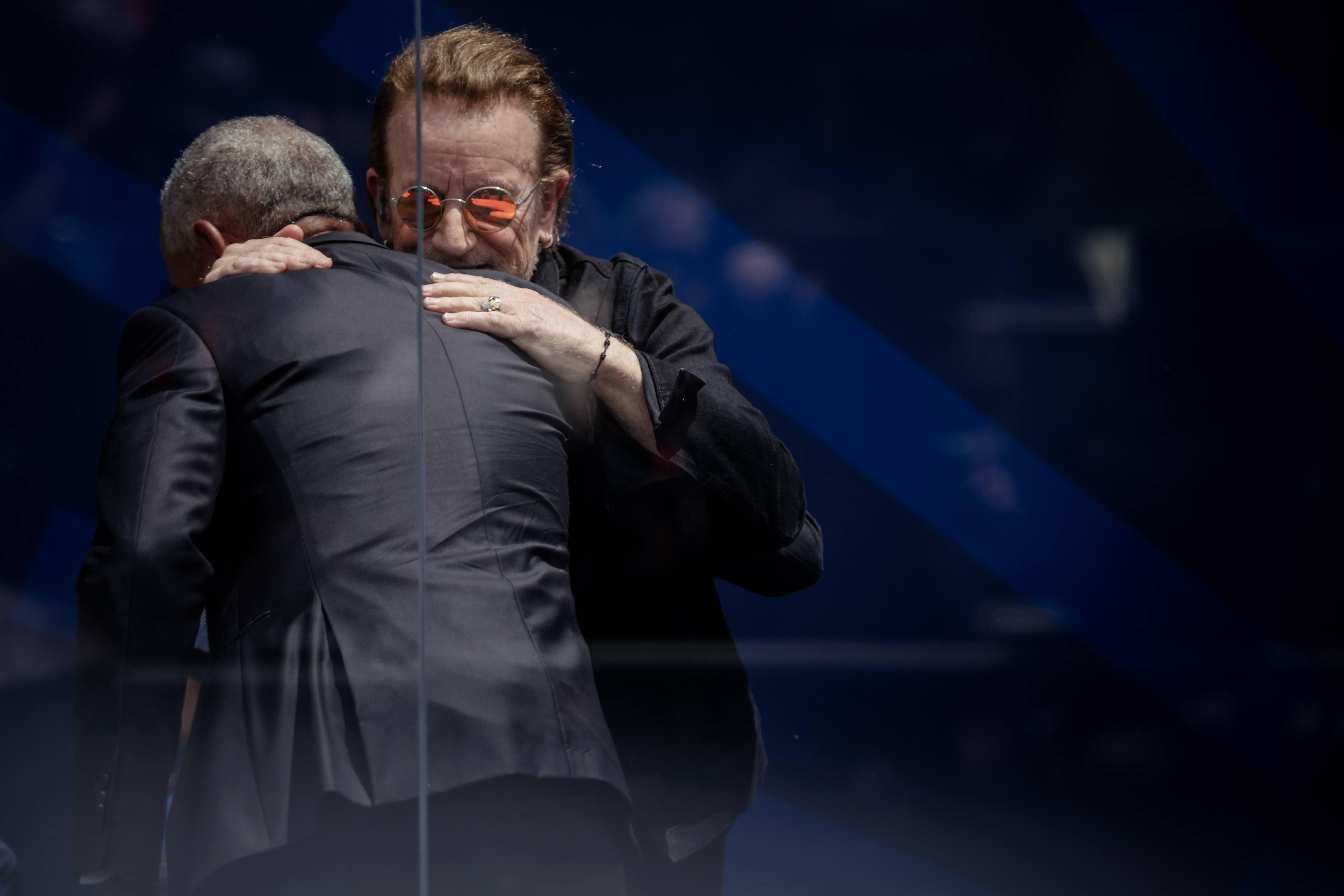 Bono embraces former President Barack Obama after his performance at...