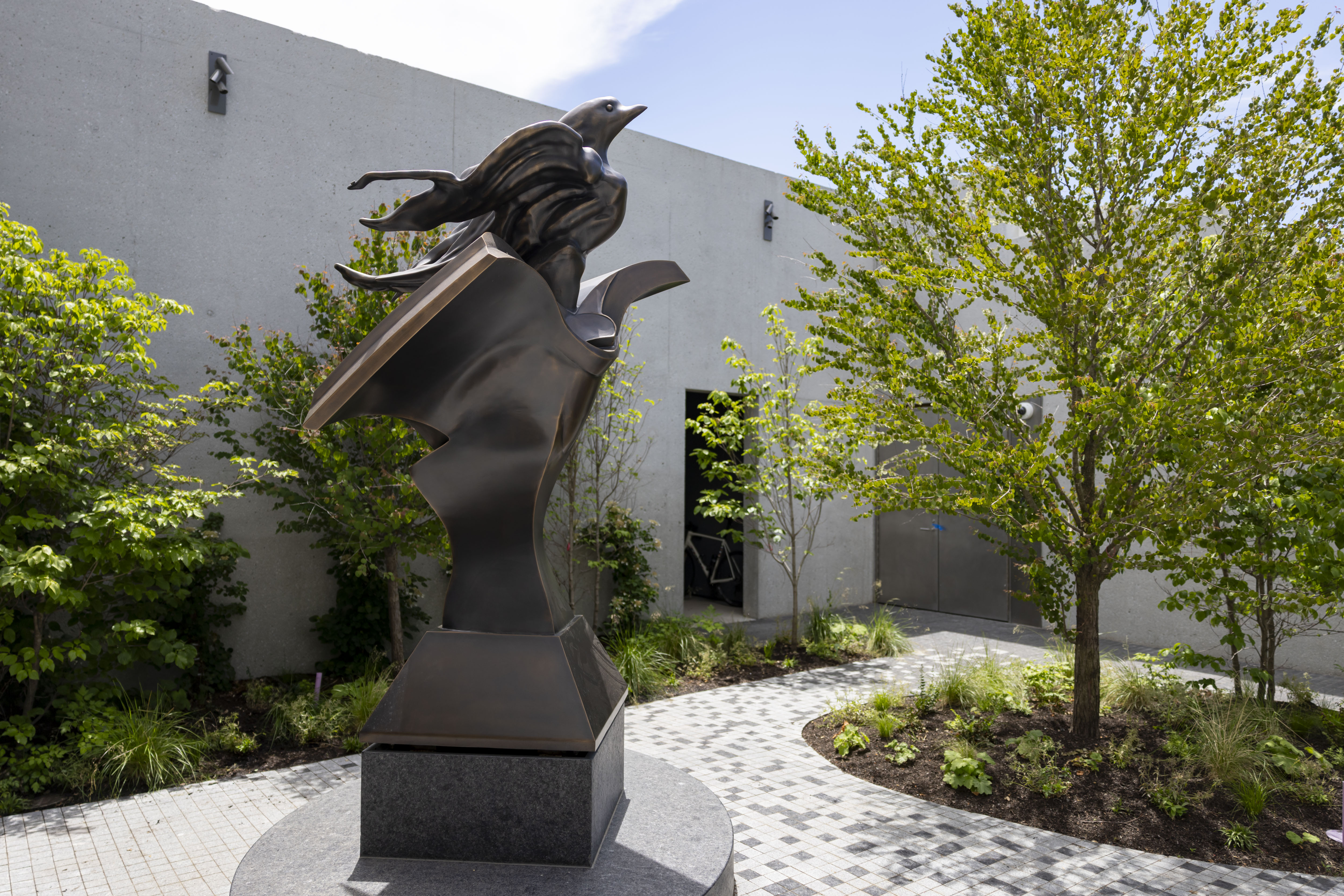 A statue by Richard Hunt sits in a courtyard outside...