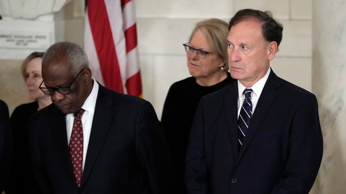 Supreme Court Justice Clarence Thomas and Justice Samuel Alito standing inside the Supreme Court building.