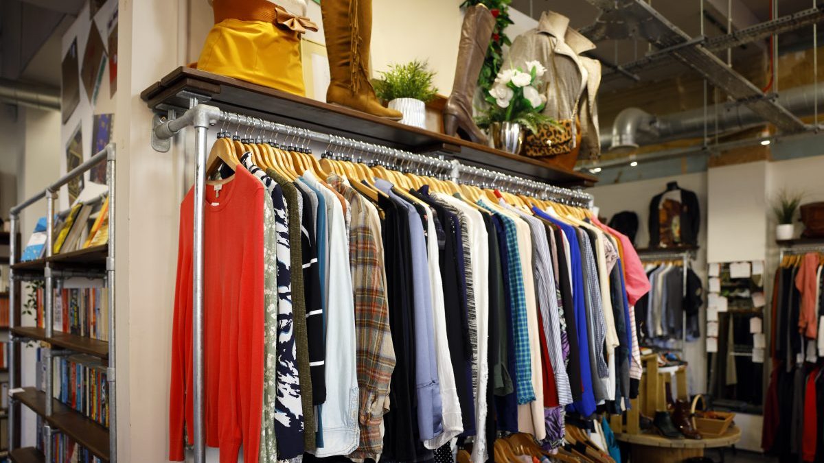A rail of clothes in a second hand vintage charity shop - stock photo