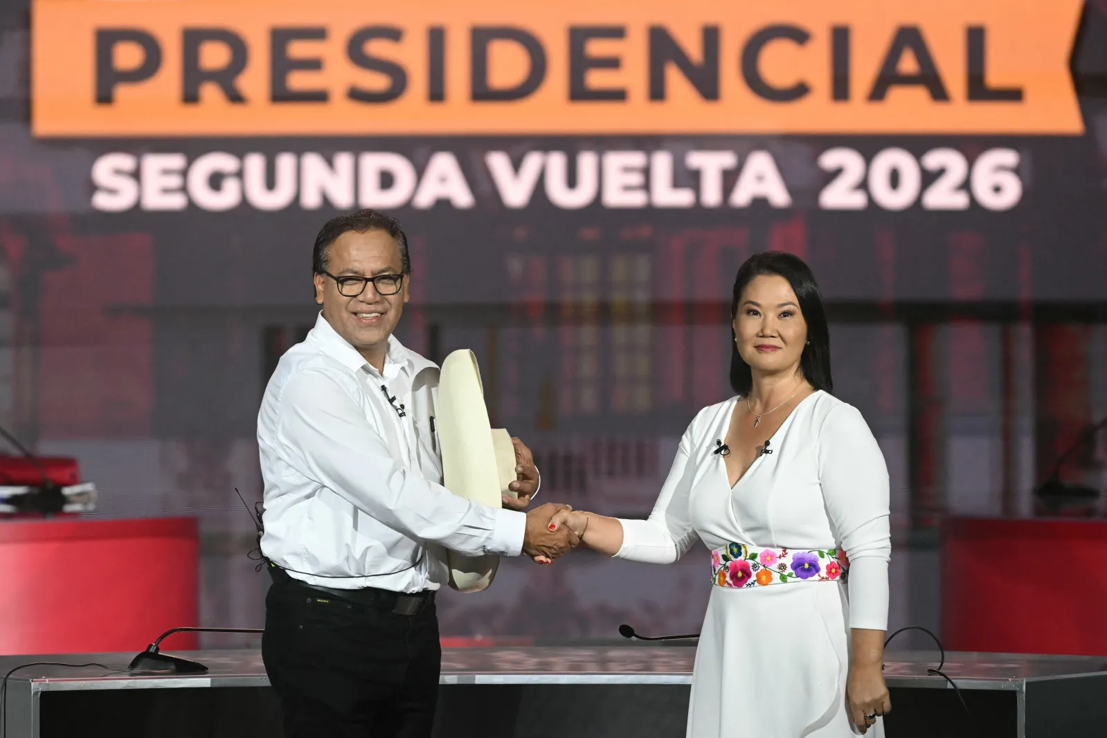 Peru's presidential candidates Keiko Fujimori, right, and Roberto Sanchez, left, shake hands during a debate in Lima on May 31, ahead of the presidential runoff election on June 7. (Photo by Ernesto Benavides/AFP via Getty Images)