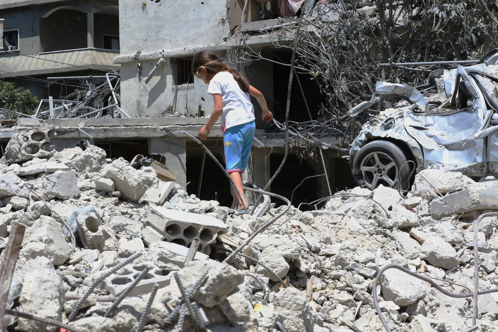 A young girl walks on top of her family's home, destroyed by the Israeli military, in Deir Qanoun en Nhar, Lebanon, on June 15, 2026.