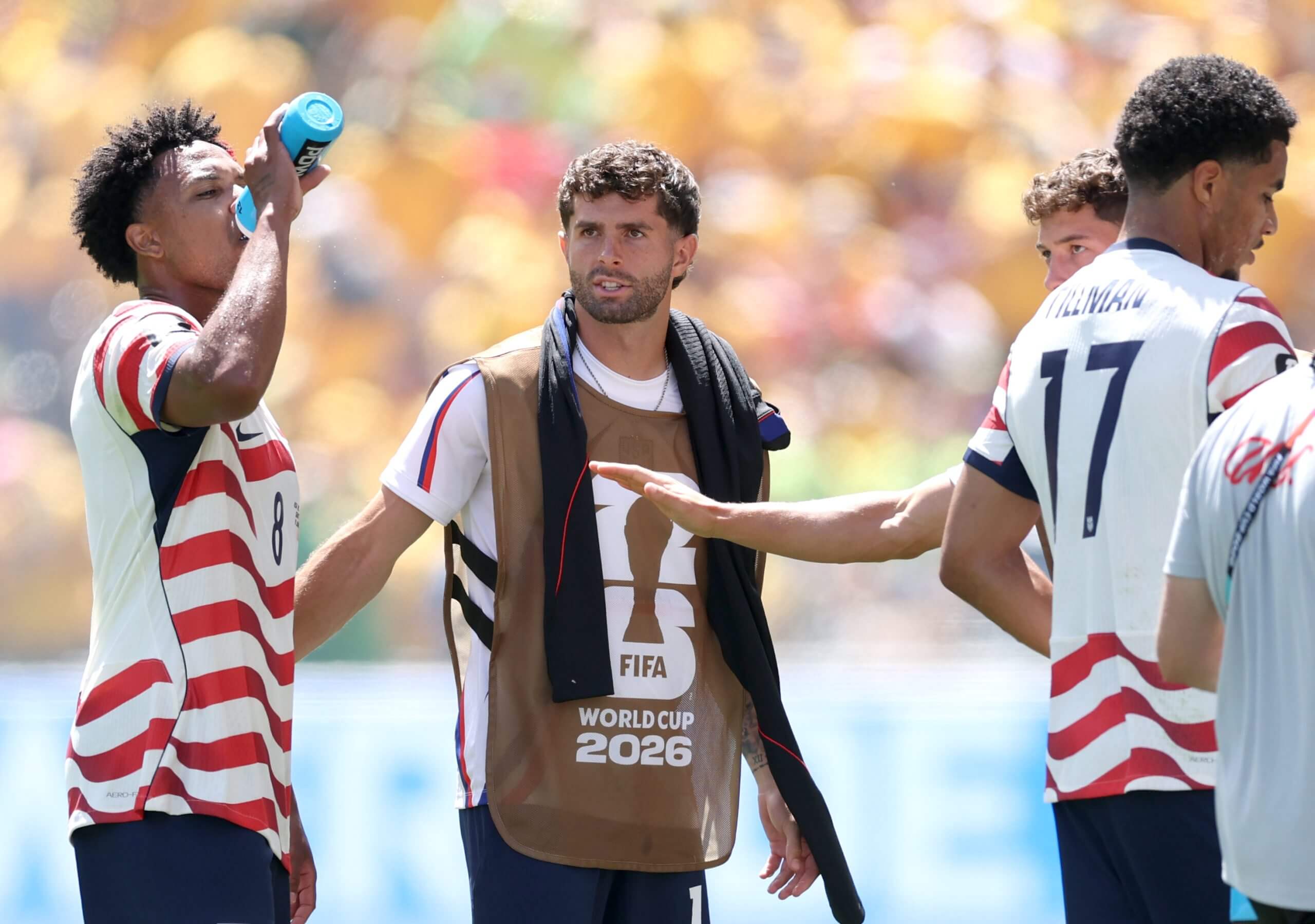 Christian Pulisic talks to USMNT players during a water break
