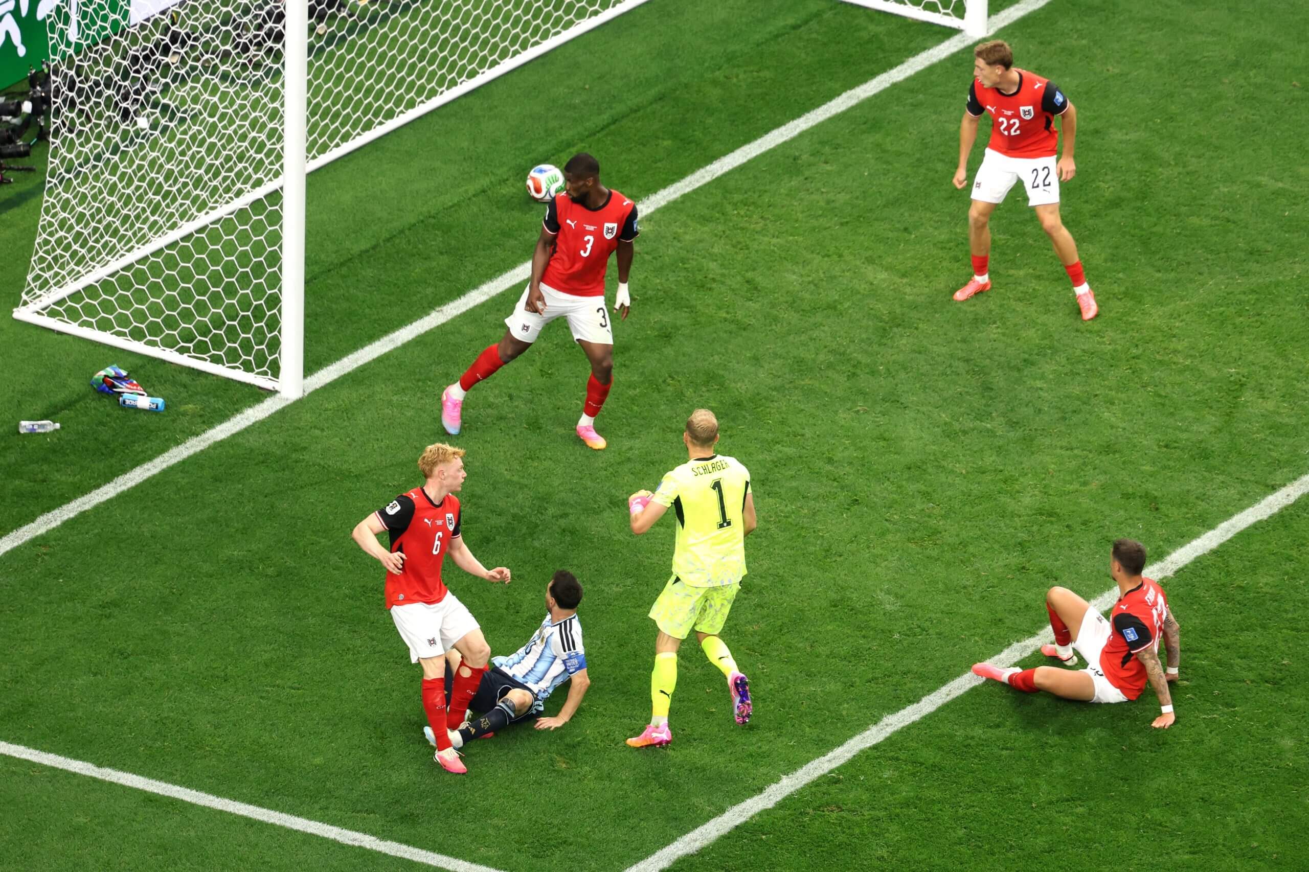 Lionel Messi is pictured on his backside as his shot evades Austria's Kevin Danso and rolls over the line for the second of his two goals